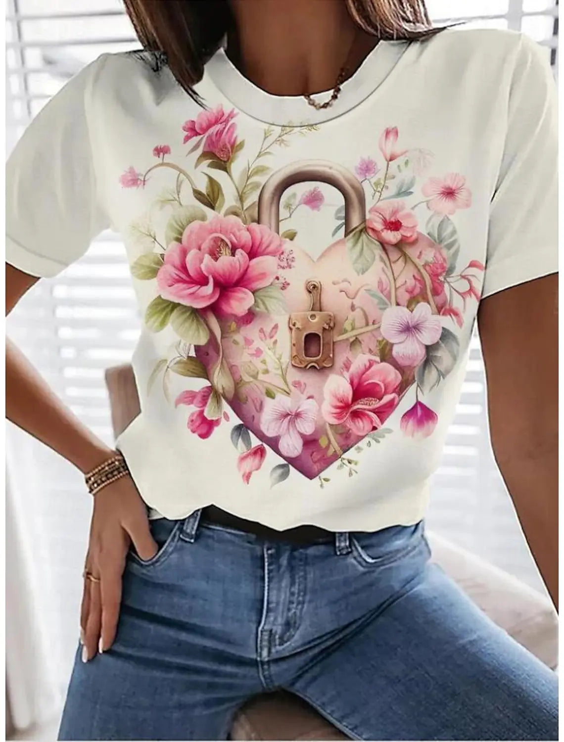 A woman wearing a white t-shirt with a pink and green rose floral print, paired with blue jeans.