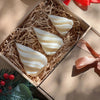 A silicone mold for a 3D geometric Christmas tree shape is shown nestled in shredded paper inside a cardboard box.