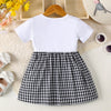 A white short-sleeved cotton knit dress with a black and white plaid skirt, displayed on a light background.