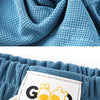 Blue textured fabric in a spiral fold, showing the detail of the Candy Color Kids' Beach Shorts with elastic waist.