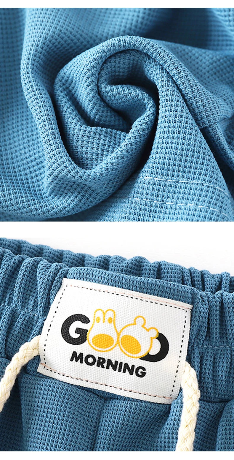 Blue textured fabric in a spiral fold, showing the detail of the Candy Color Kids' Beach Shorts with elastic waist.