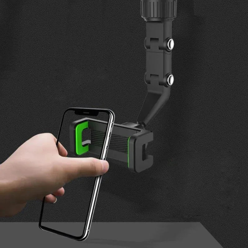 A hand holds a smartphone attached to a black, multi-position mount designed for various surfaces.