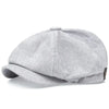 A grey vintage retro newsboy cap with a folded brim shown from the side.
