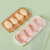 A wooden tray holds silicone popsicle molds with pink and yellow colored ice cream shapes.