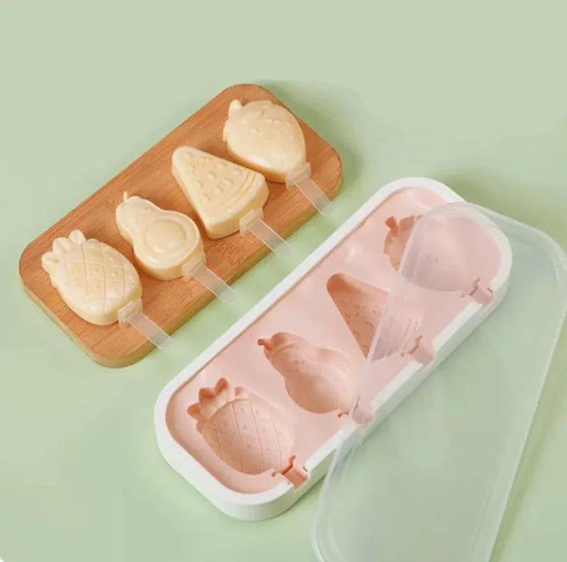 A wooden tray holds silicone popsicle molds with pink and yellow colored ice cream shapes.