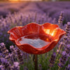 A handcrafted metal flower garden stake with a bird bath filled with water, set against a field of purple lavender.