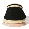 A stack of three woven straw sun hats in black, beige, and pink.