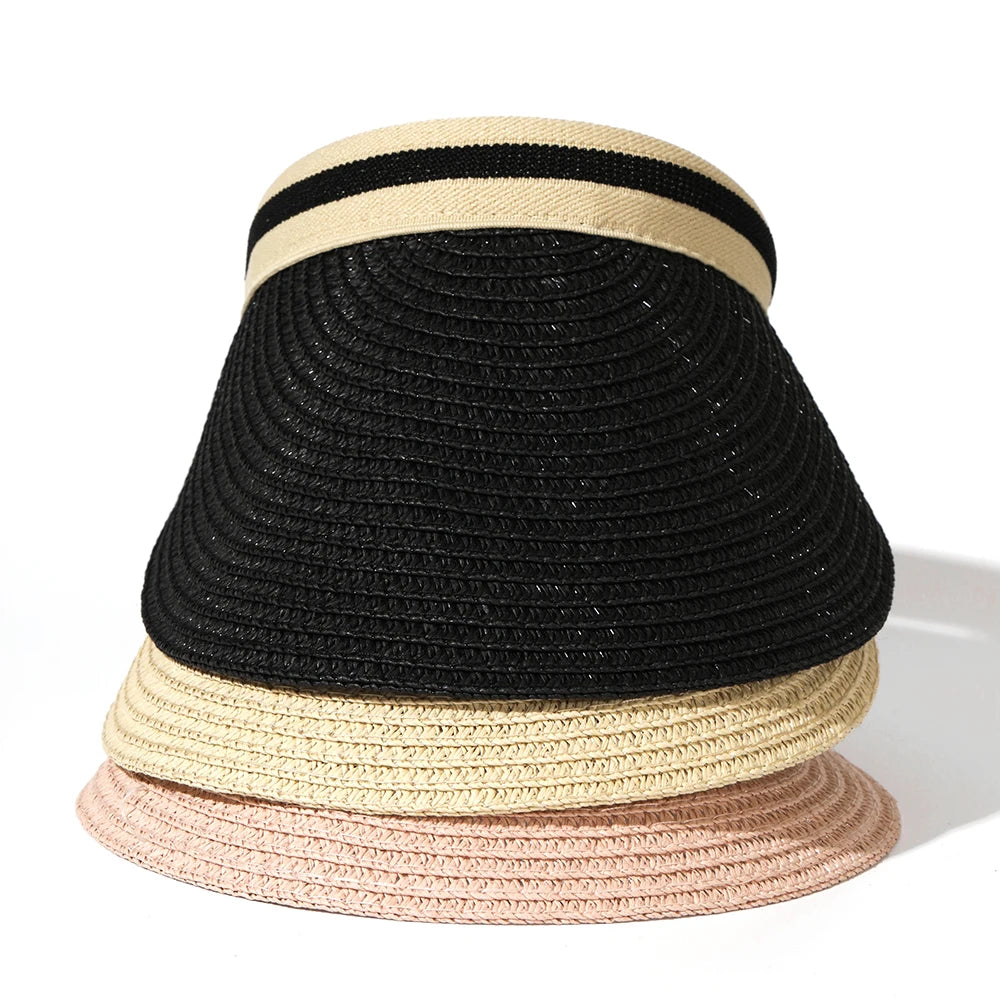 A stack of three woven straw sun hats in black, beige, and pink.