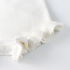 A white soft knitted baby romper with a ruffled edge shown from the front.