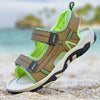 A pair of olive green and lime green breathable summer sport sandals resting on light sand near the water.