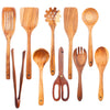 A collection of natural teak wood cooking utensils including spatulas, spoons, forks, and graters.