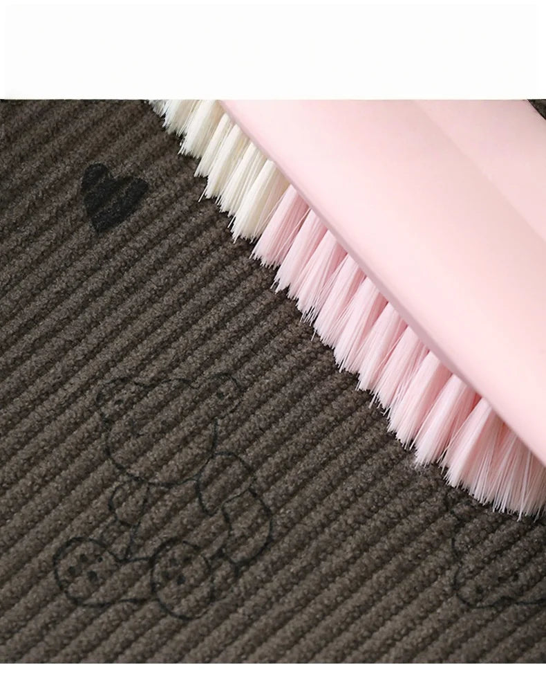 Close-up of a pink brush with white bristles resting on dark brown fleece fabric.