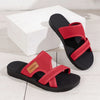 A pair of red breathable mesh flat sandals with black soles resting on a white surface.
