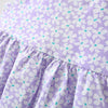 A close-up of a purple floral dress for a baby girl with a ruffled hemline.