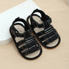 Black baby summer sandals with non-slip rubber soles displayed on a light background.