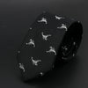 Corbata negra con estampado de cebra plateado o blanco, enrollada sobre una superficie oscura.