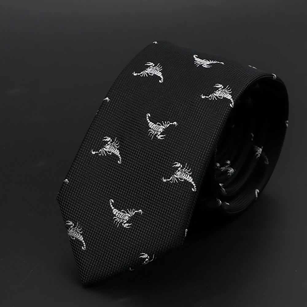 Corbata negra con estampado de cebra plateado o blanco, enrollada sobre una superficie oscura.