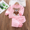 Pink fleece pajama set for a child featuring a teddy bear design and matching pants.