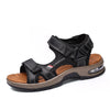 A pair of black leather air cushion sandals with a tan sole and strap details.