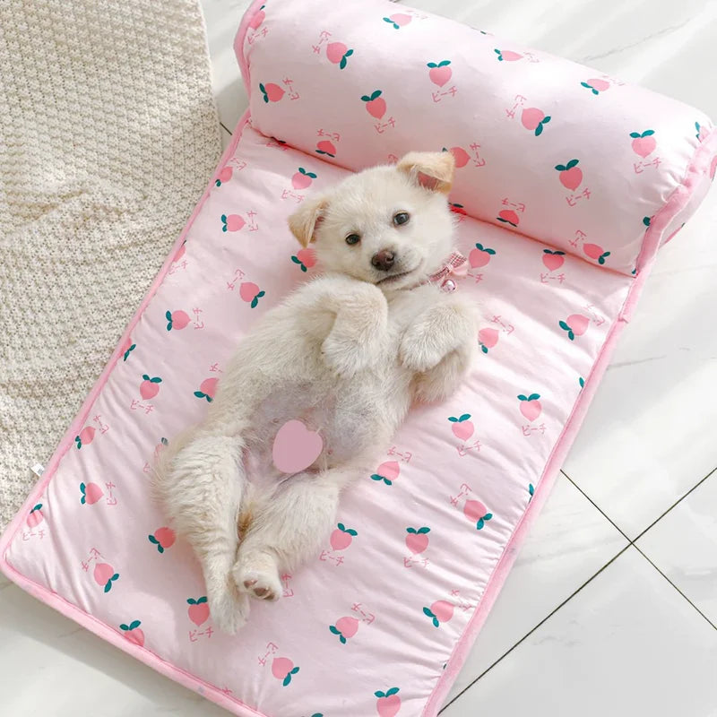 A fluffy white puppy is lying on a pink ice silk pet cooling mat with small fruit patterns.