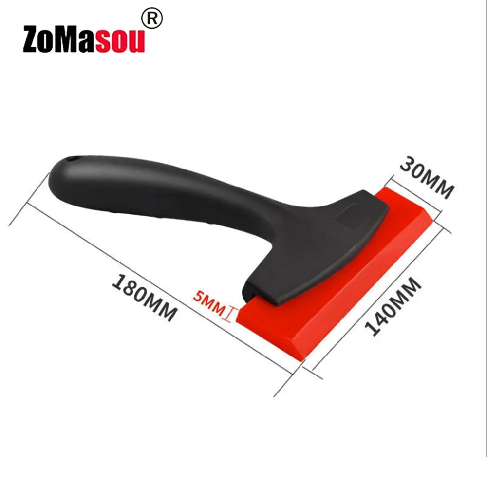 A black tile gap filling and cleaning scraper tool with a handle, shown from above.