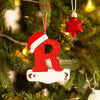 Rød glitter akryl bokstav R hengende på en grønn juletregren.
