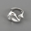 A silver gold starfish pearl ring with an adjustable band, photographed on a gray surface.