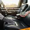 A hand applies clear leather conditioner balm to a black car seat interior.
