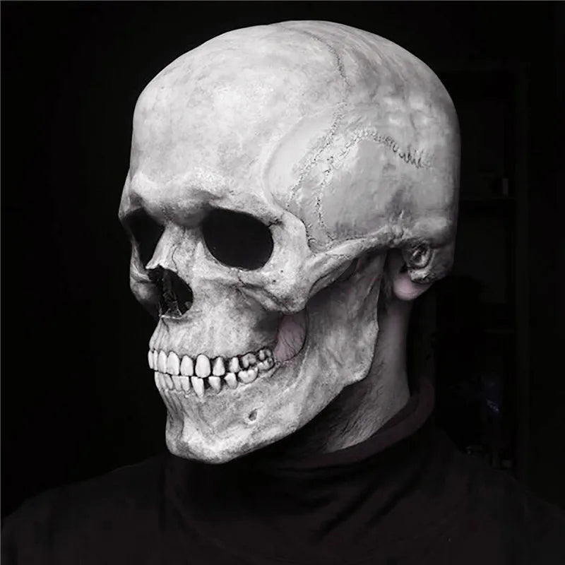 Máscara realista de calavera completa con mandíbula móvil, en blanco y negro sobre fondo oscuro.