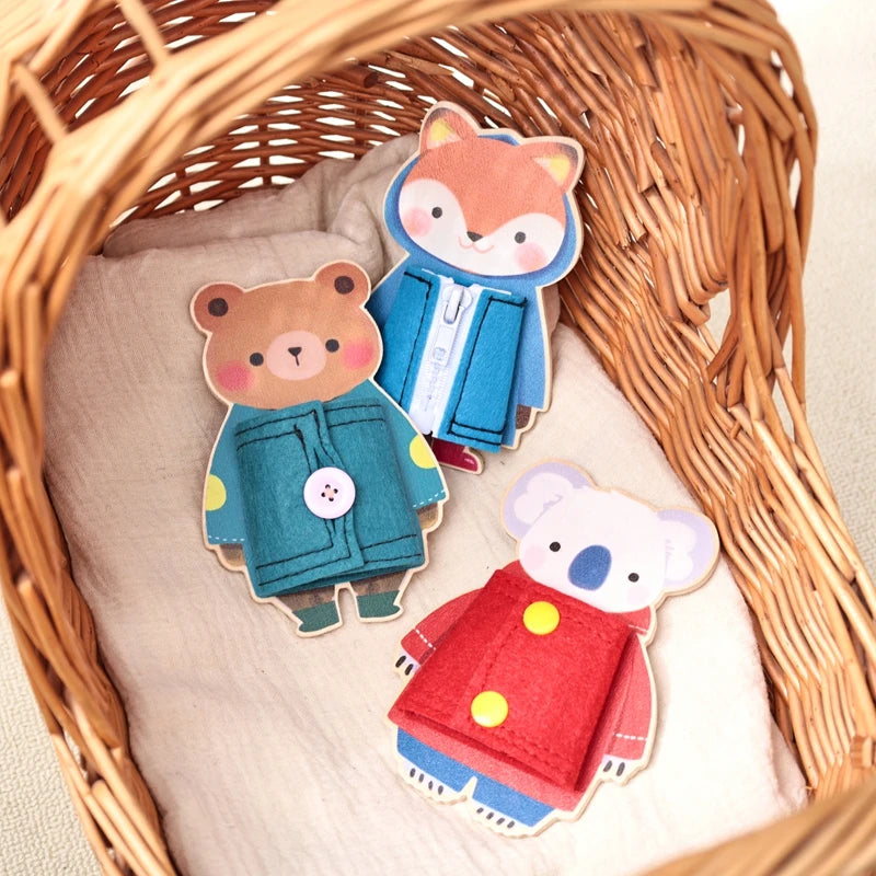 Three wooden felt animals, a fox, a bear, and a panda, are displayed inside a woven basket.