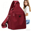 A maroon mini backpack for women shown next to a woman.