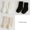 A set of three fuzzy socks in white, black, and beige colors displayed against a white background.