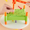A hand is using an orange Montessori hammer and nail toy to drive a red nail into a green block for fine motor skill developm