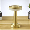 A brass rechargeable touch table lamp with a white shade sits on a wooden surface.