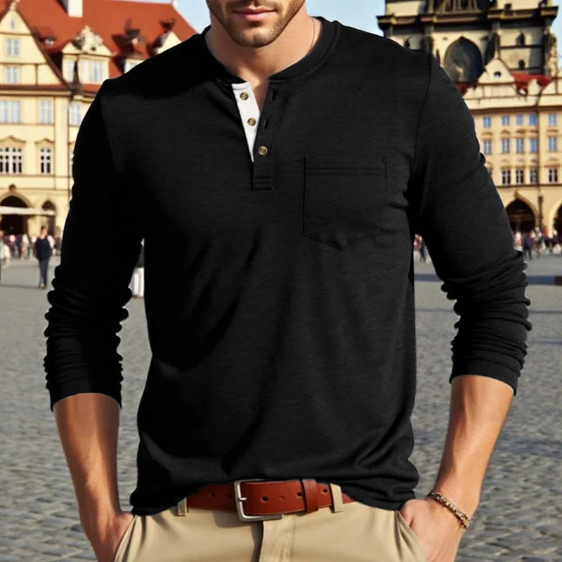 A man wearing a black long-sleeve casual shirt with a collar and chest pocket, standing outdoors.