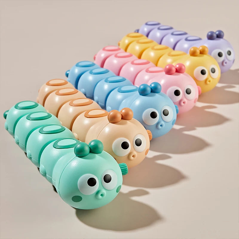 A set of colorful wind-up crawling animal toys, including worms and reptiles, arranged in a row.