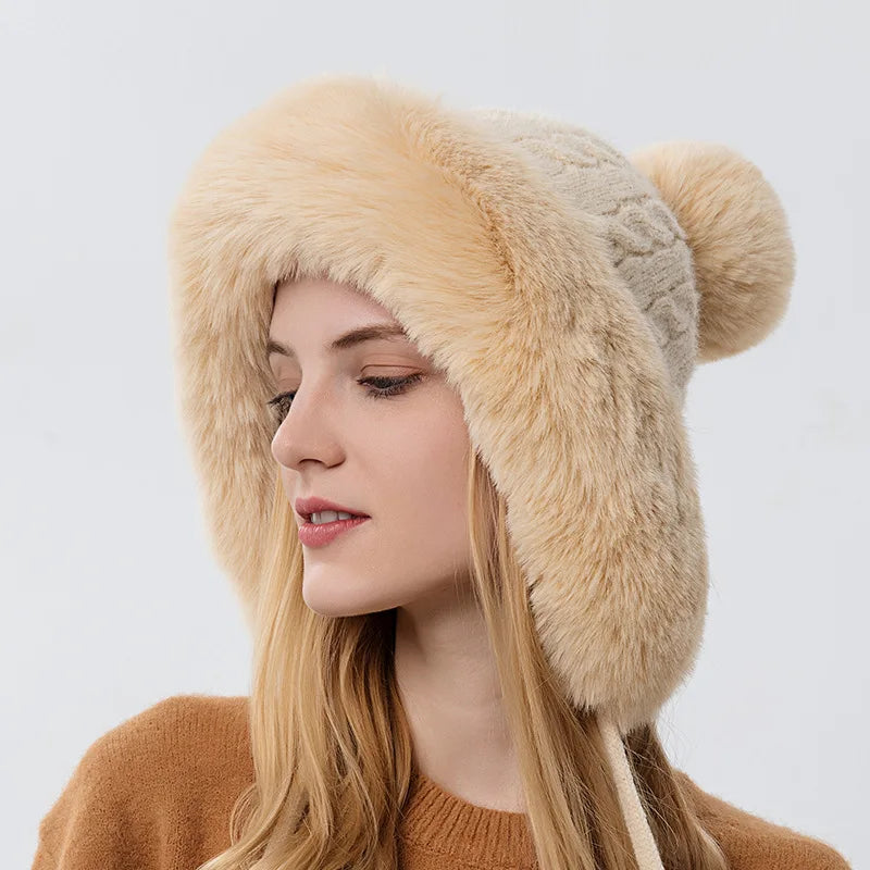 A woman wearing a beige knitted hooded scarf with a fluffy trim and a face mask.