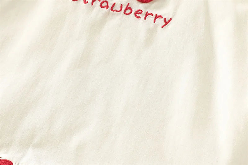 White kids summer pinafore dress featuring a strawberry and bunny print detail.