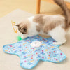 A fluffy tabby cat is playing with a blue motion-activated hide and seek toy on a light surface.