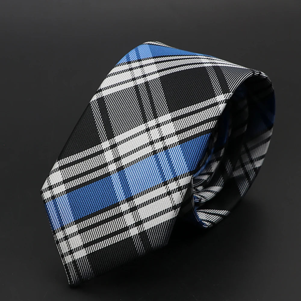 Corbata de cuadros blancos y negros con rayas azules, doblada sobre fondo oscuro.