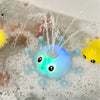 A blue light-up whale bath toy is spraying water in a bathtub filled with bubbles.