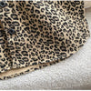 Close-up of a tan leopard print denim jacket with dark buttons and a beige lining.