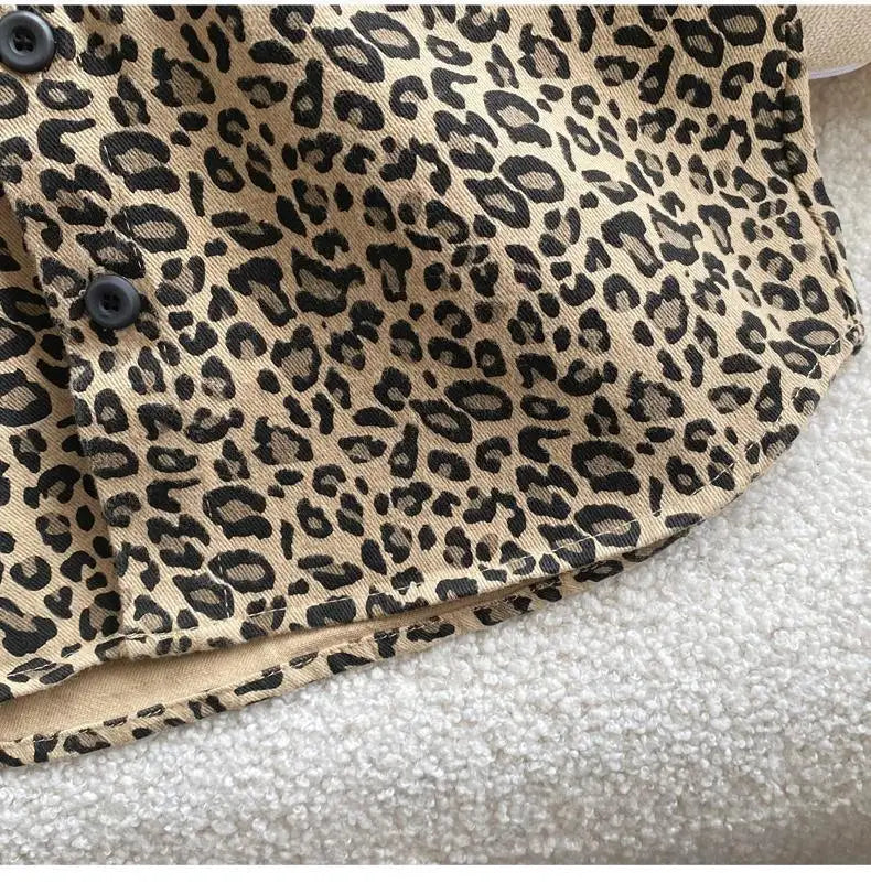 Close-up of a tan leopard print denim jacket with dark buttons and a beige lining.