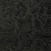 Close-up texture of black vintage floral patterned faux leather fabric.