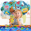 A young child is looking at a colorful felt story board featuring various zoo animals like a green turtle and a blue whale.