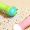 A close-up of a green and blue kids' animal backpack water gun toy resting on a surface with small white beads.