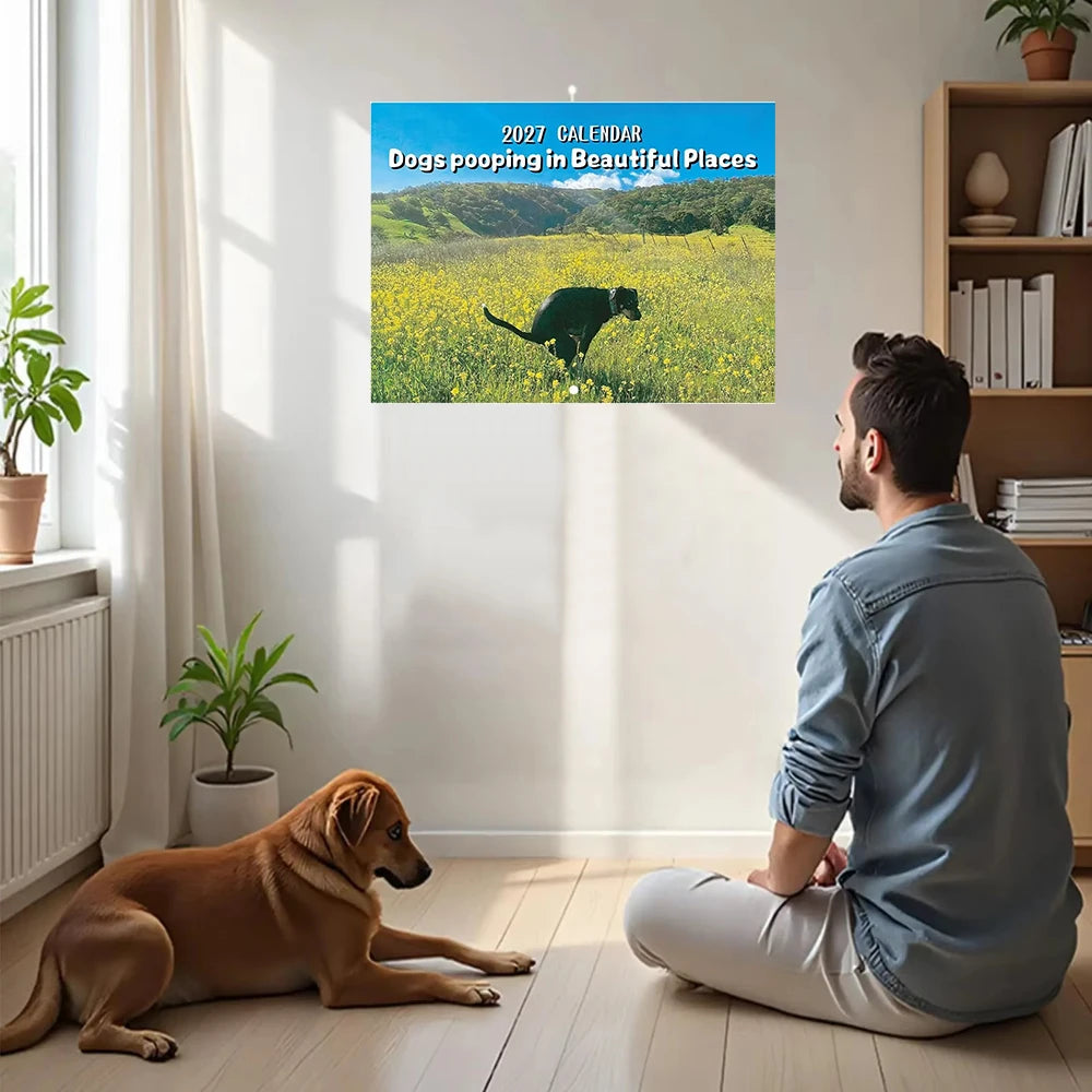 En mann sitter på gulvet og ser på en kalender med tittelen 2027 Dogs Pooping in Beautiful Places, med en hund i nærheten.