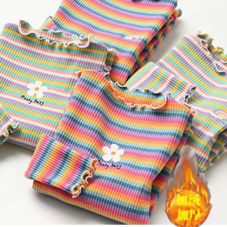 A stack of girls' color stripe flower print t-shirts in various pastel colors.