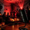 Halloween-projektorlampe med seks røde lysskiver oplyser et uhyggeligt indendørs sceneri.