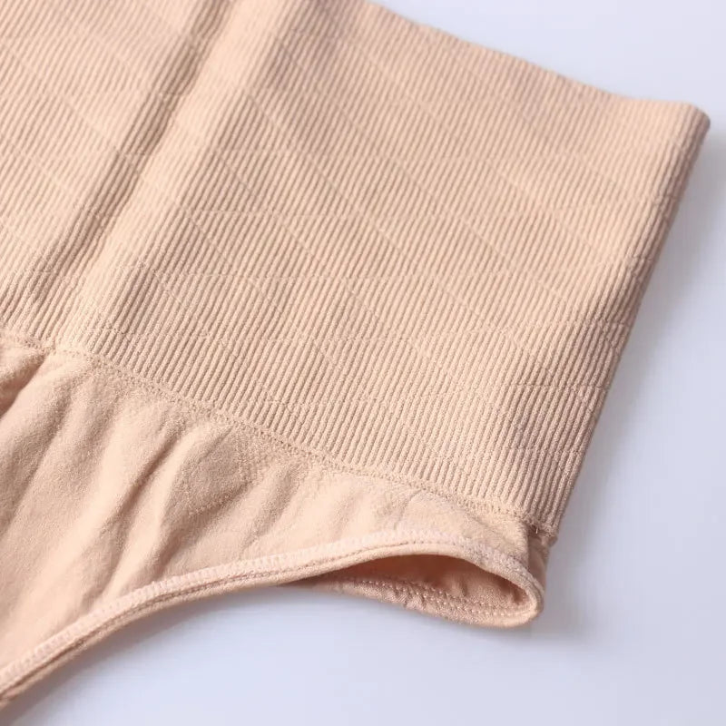 A close-up of a beige high-waist tummy control thong shaper garment.